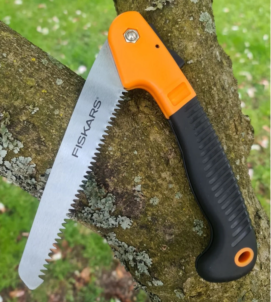 Fiskars Klappsäge mit scharfem Präzisionssägeblatt und ergonomischem Griff bei der Holzarbeit am Baum – robuste Handsäge für Feuerwehr, THW, Rettungsdienst, Forstarbeit, Bushcraft, Camping und Outdoor-Einsätze zum schnellen Sägen von Ästen und Holz.