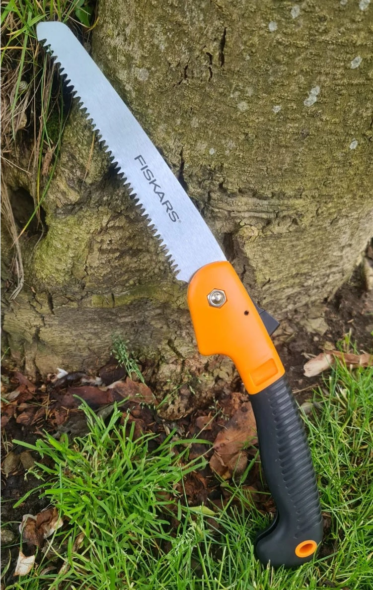 Fiskars Klappsäge in eingeklappter Transportposition mit ergonomischem Softgrip-Griff und sicherer Verriegelung – kompakte Handsäge für Feuerwehr, THW, Rettungsdienst, Forstarbeit, Bushcraft, Camping und Outdoor-Einsätze zur sicheren Mitnahme im Einsatzrucksack oder Fahrzeug.